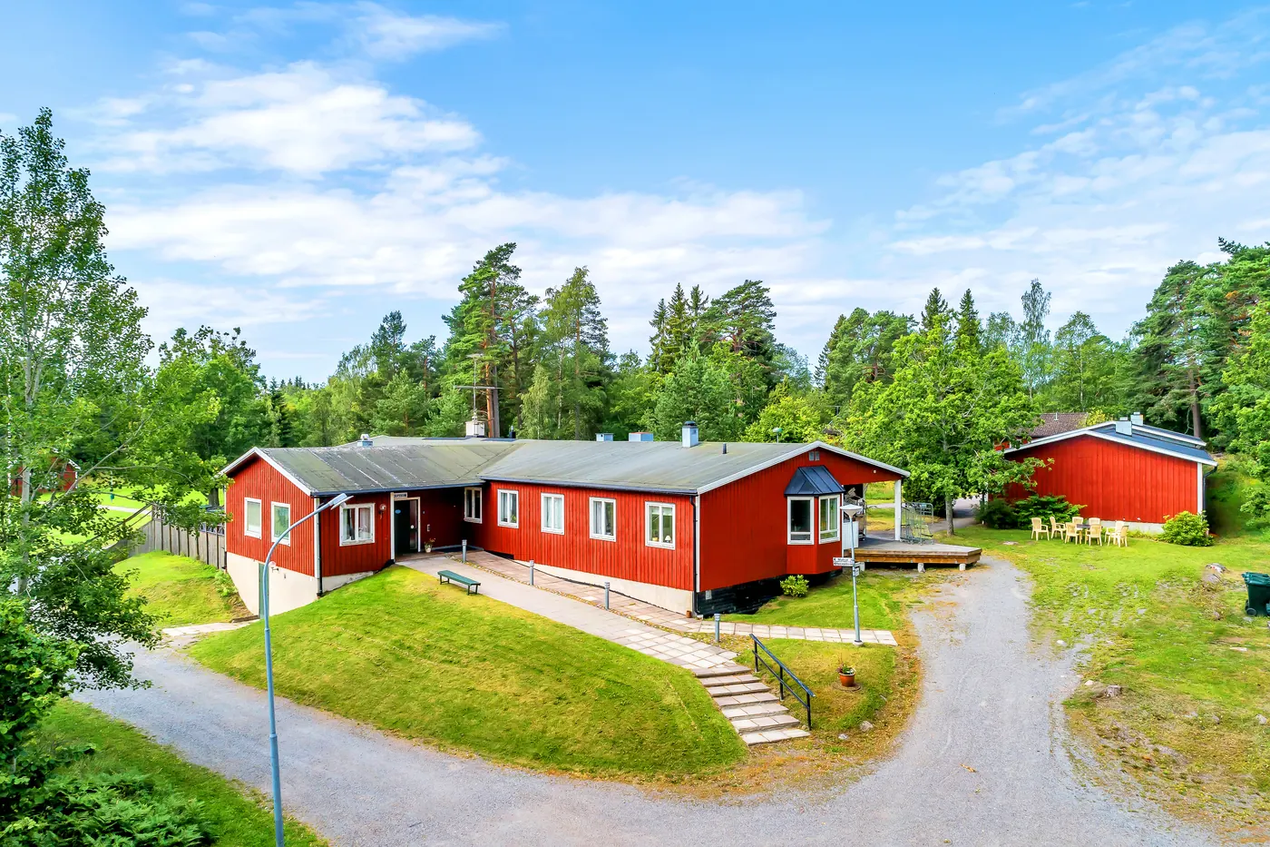 Grusvägen upp till huvudbyggnaden, med grässlänt och trappa