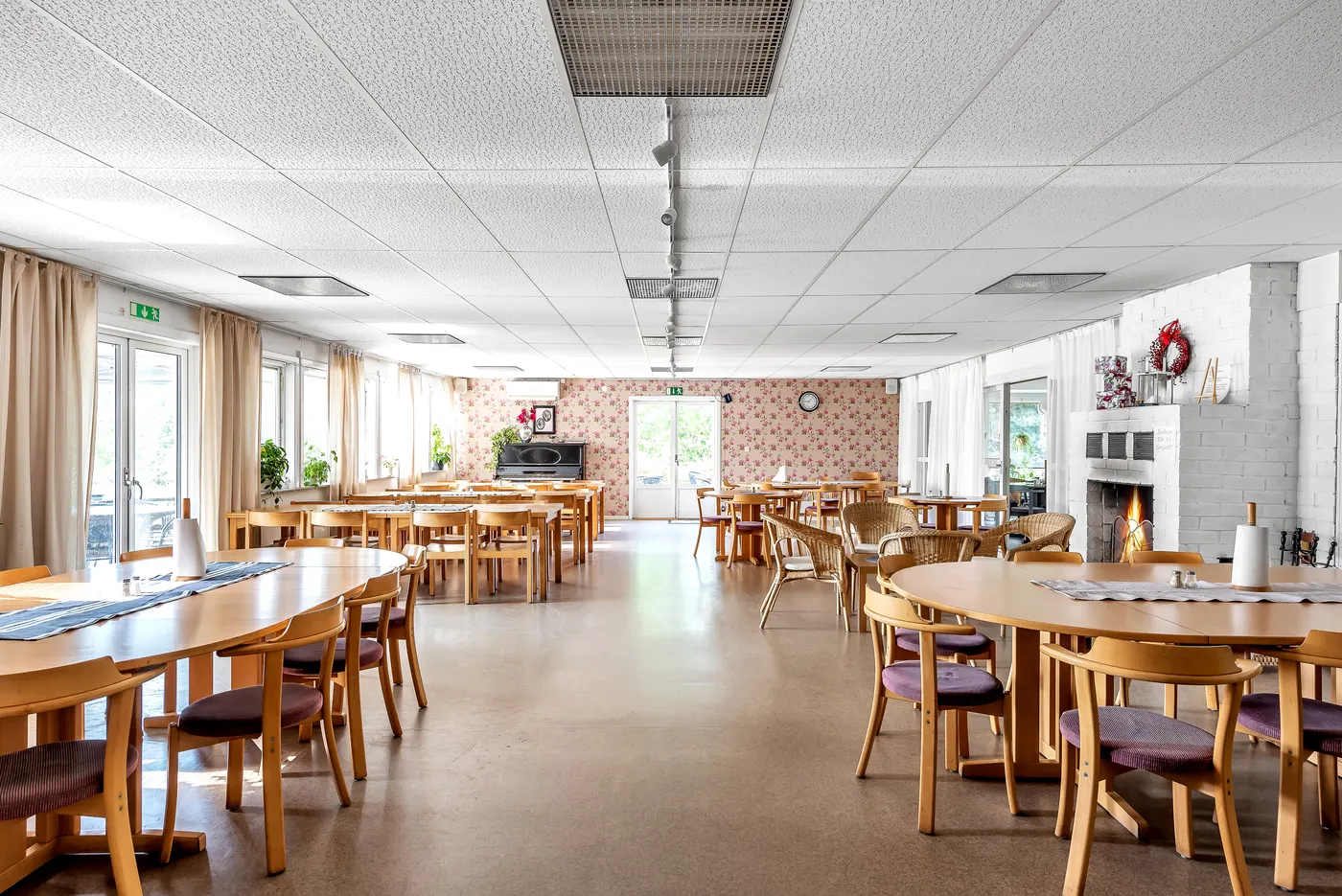 Matsalen med dukade bord och en brasa i den öppna spisen