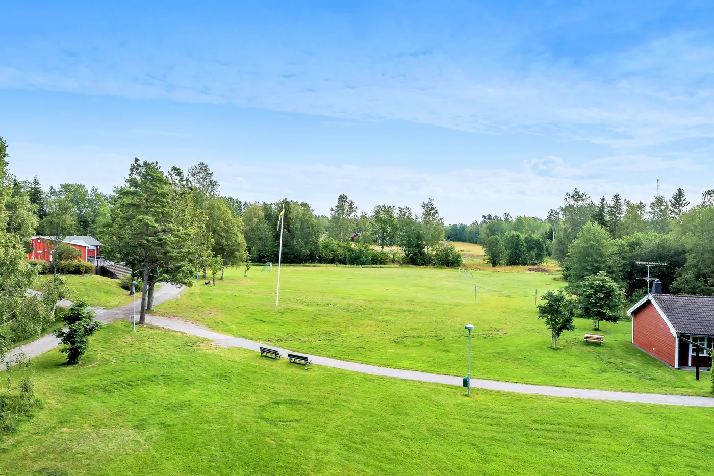 Den stora öppna gräsytan mitt på gården, omgiven av skog